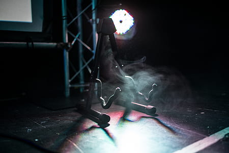 black metal guitar stand on lighted stage thumbnail