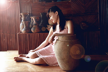 woman sitting beside brown ceramic vase thumbnail