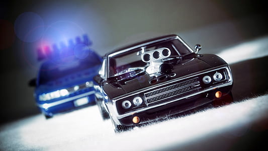 selective focus photography of two black and blue vehicles thumbnail