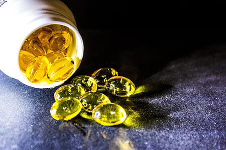 yellow medication pill container spilled on black textile thumbnail