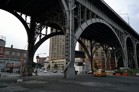 people and cars under gray bridge thumbnail