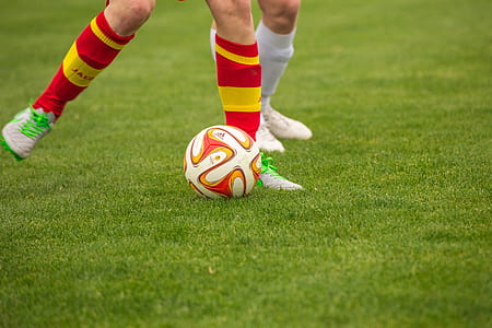 person standing near soccer ball in field during daytime thumbnail