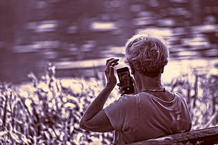 grayscale photography of woman sitting on bench while calling on phone thumbnail