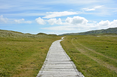 road between green grass field towards mountain thumbnail