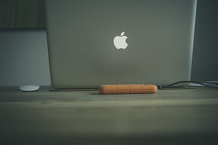 turned-on MacBook on beige table thumbnail
