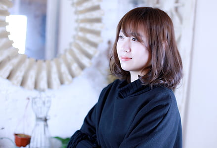 woman wearing black sweater near wall-mount mirror thumbnail