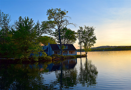 photography of white and brown house beside body of water thumbnail