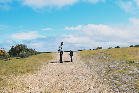 man and child standing on grassy path thumbnail