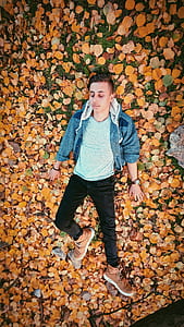 Closeup Photo of Man Lying on Brown Leaves thumbnail