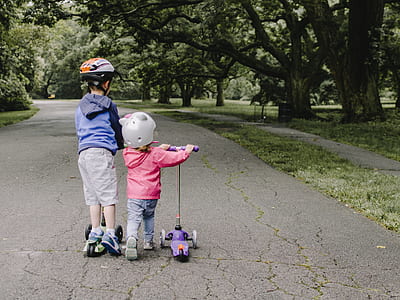 two children's playing kick scooters thumbnail