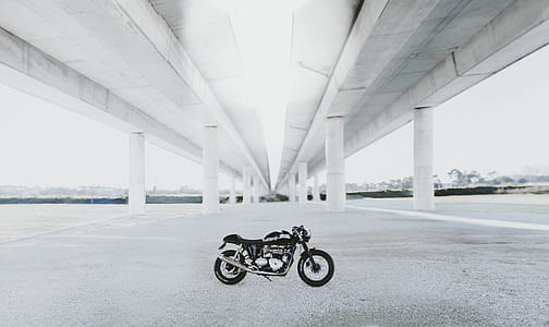 photography of parked black standard motorcycle under bridge thumbnail