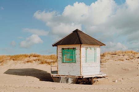white wooden shed near seashore during daytime thumbnail