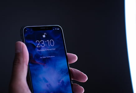 person holding space gray iPhone X at 23:10 screenlock thumbnail