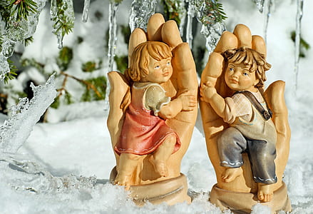 two boy and girl figurines on snow covered surface thumbnail