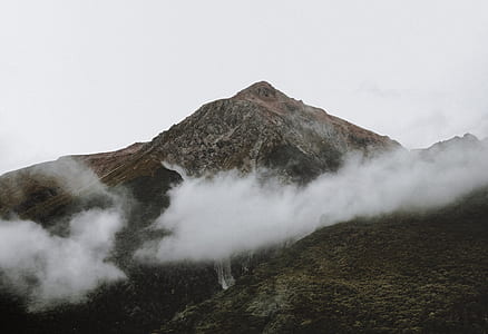 green plant-covered mountain during foggy day thumbnail