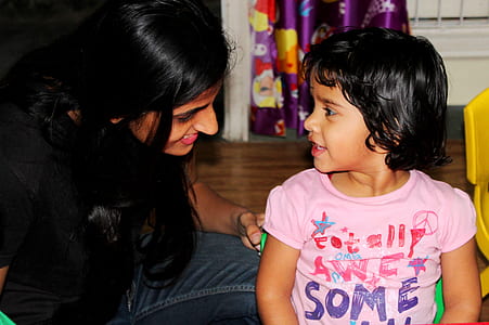 woman sitting beside girl in pink T-shirt thumbnail
