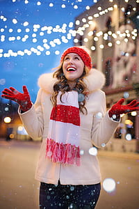 woman wearing white parka and red and white striped scarf in tilt shift lens shot thumbnail
