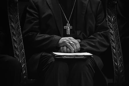 man wearing in black wearing gold cross necklace thumbnail