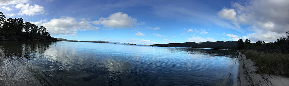 large body of water under blue and white sky at daytime thumbnail