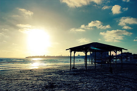 silhouette of gazebo near body of water thumbnail