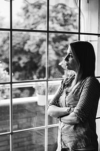 Grayscale Photo of Woman Standing Beside Mirror thumbnail