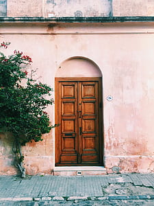 brown wooden door closed inside beige concrete building thumbnail