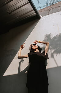 woman standing beside concrete wall during daytime thumbnail
