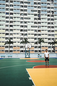 green, red, and yellow basketball court beside white building thumbnail