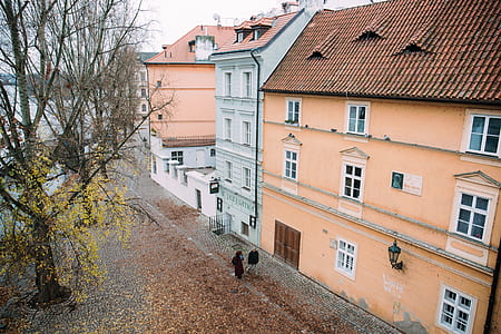 two persons walking in front of beige house thumbnail