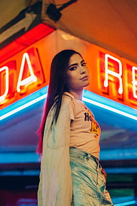 woman standing near neon light signage thumbnail