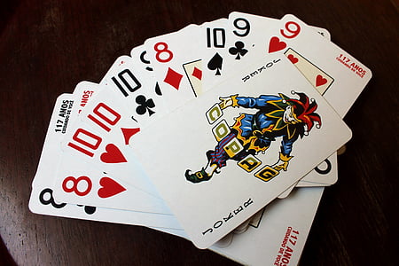 several playing cards on brown wooden table thumbnail