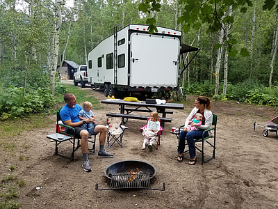 people camping near white RV trailer thumbnail