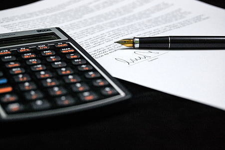 black desk calculator beside black fountain pen thumbnail