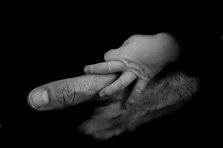 grayscale photo of baby holds man's hand thumbnail