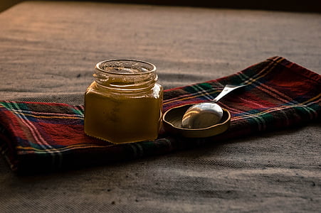 glass jar beside silver spoon on red mat thumbnail