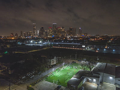 green soccer field and city buildings in night time thumbnail