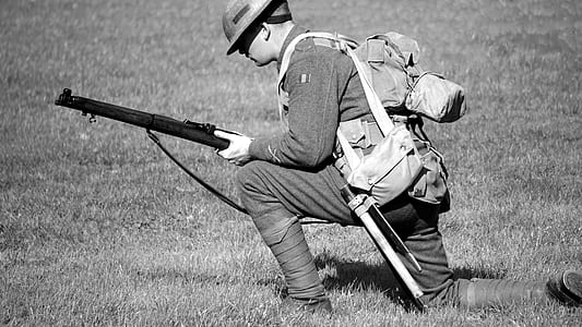Man in Soldier Suit Holding Gun Knees Down in the Ground thumbnail