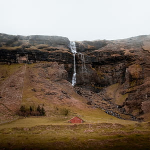 brown house under waterfalls thumbnail
