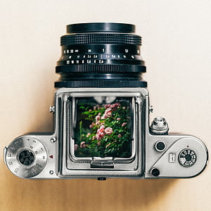 grey and black DSLR camera on brown wooden surface thumbnail