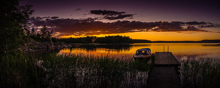 silhouette of boat on body of water thumbnail