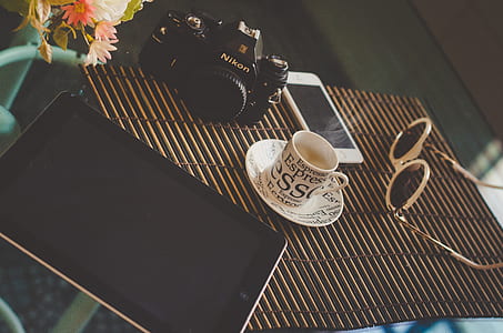 black iPad on table near Nikon DSLR thumbnail
