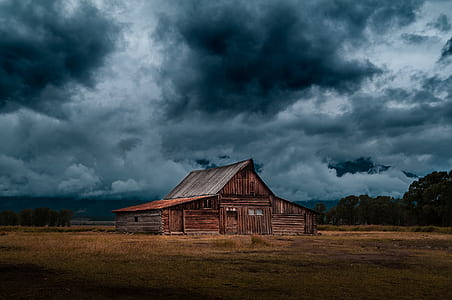 brown wooden house under cloudy sky thumbnail