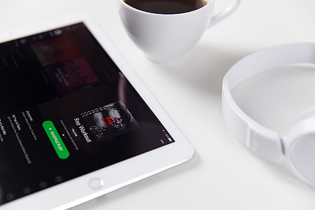 White iPad tablet computer alongside music headphones and coffee thumbnail