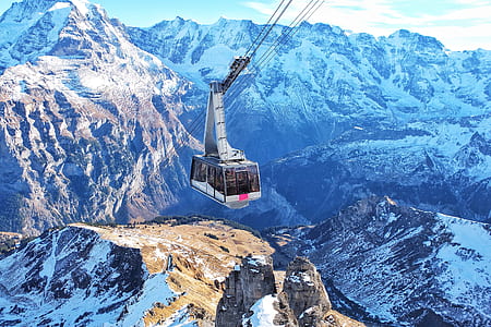 photo of white and gray cable cart with snow capped mountain thumbnail
