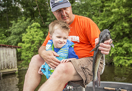 man hugging toddler holding catfish thumbnail