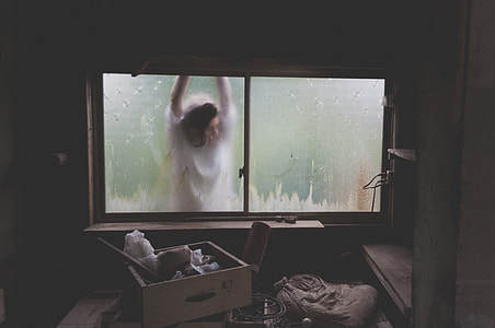 woman in white top standing in front of glass window thumbnail