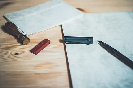 fountain pen and stamp on brown surface thumbnail