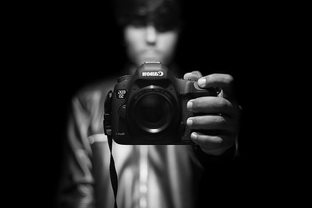 person holding Canon DSLR camera thumbnail