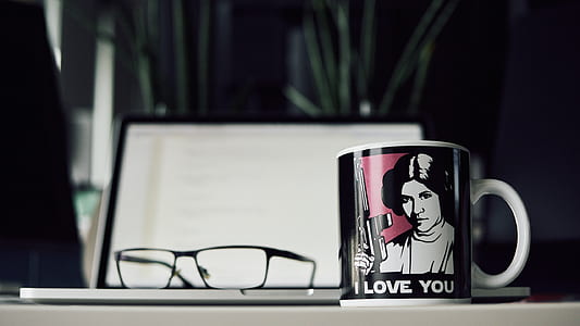 white and black ceramic mug beside black framed eyeglasses thumbnail