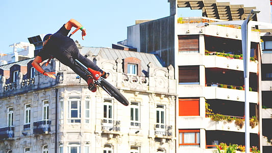 man performing a BMX bike trick under clear blue sky thumbnail